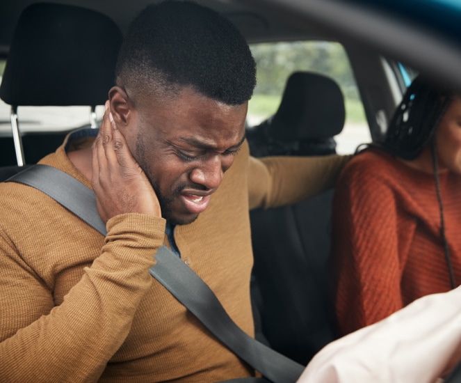 man in car with neck pain